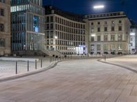 an empty and empty city plaza at night with people walking by it in the evening