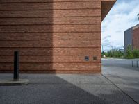 an image of a brick building near the street outside of a city center area,