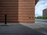 an image of a brick building near the street outside of a city center area,