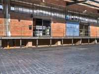 a bicycle parked outside of the side of an old building with benches and barriers around it