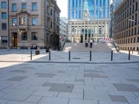 a sidewalk that has a long curved walkway and several buildings behind it in the city