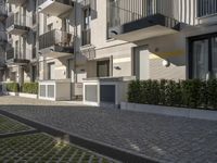 the street between buildings and the cobblestones in front of the sidewalk, shows apartment blocks along the edge