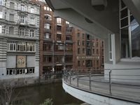 some buildings are next to a body of water and a bridge with people on it