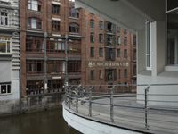 some buildings are next to a body of water and a bridge with people on it