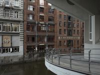 some buildings are next to a body of water and a bridge with people on it