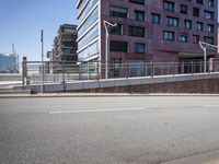 an empty city street with buildings and a truck on the side of it next to rocks