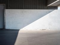 an empty building with a door and a wall with some light on it is empty and has a white door