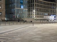 an empty plaza with a lot of tables and stairs on each side, in the middle of a city street