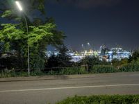 an illuminated street light shines over a city with lots of construction in the distance