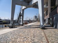 an old looking railroad track near the water and buildings and stairs going up to the roof