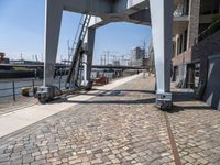 an old looking railroad track near the water and buildings and stairs going up to the roof