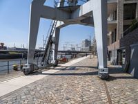 an old looking railroad track near the water and buildings and stairs going up to the roof