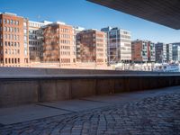 a stone walkway leading to a building in a city with brick pavers under it