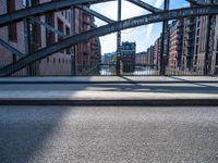 a view of a bridge leading to buildings across the river with a bicycle attached to the end