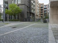 a person walking down an empty street past tall buildings on either side of the road