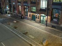 view looking down on some buildings in a town with cobbles and signs on each side