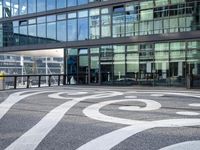 the sidewalk is painted with decorative designs near a building's windows and bicycle racks