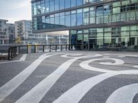 the sidewalk is painted with decorative designs near a building's windows and bicycle racks