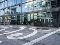 the sidewalk is painted with decorative designs near a building's windows and bicycle racks