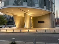 a building that is lit up for the day and has columns surrounding it with lamps