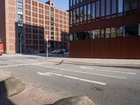 an empty city street with buildings and a truck on the side of it next to rocks