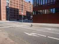 an empty city street with buildings and a truck on the side of it next to rocks