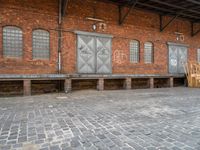 a red brick building that has a bench in front of it and windows behind it
