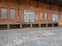 a red brick building that has a bench in front of it and windows behind it