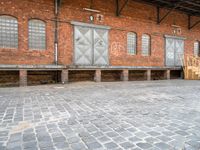 a red brick building that has a bench in front of it and windows behind it