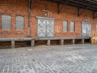 a red brick building that has a bench in front of it and windows behind it