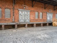 a red brick building that has a bench in front of it and windows behind it