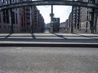 the shadow of the man is shown on a street bridge over the canal, and he looks on