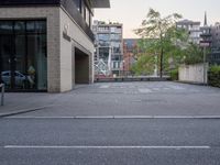 a empty parking lot outside a large brick building on a street corner in the city