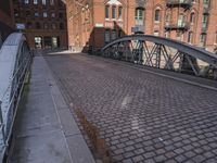 the walkway leading to the river is made up of cobblestone tiles and steel