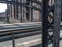 a view of the inside of an old city bridge from an empty train track,