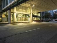 a woman walking down the road in an office building at night in the city center