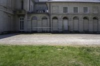 a courtyard with a clock tower and two tall windows is shown on the building's right side