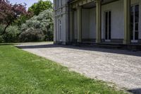 green lawn that has a lawn sign on it on the side of a building with some windows