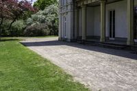 green lawn that has a lawn sign on it on the side of a building with some windows