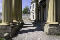 a couple of columns sitting inside of an old building with grass on the outside and two on the top