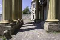 a couple of columns sitting inside of an old building with grass on the outside and two on the top