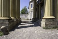 a couple of columns sitting inside of an old building with grass on the outside and two on the top