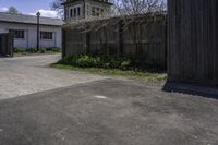 a large white clock tower standing next to a wood fence and walled in area