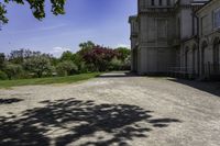 a long gravel driveway with a clock tower in the distance, and trees in the foreground