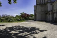 a long gravel driveway with a clock tower in the distance, and trees in the foreground