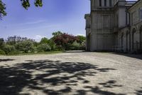 a long gravel driveway with a clock tower in the distance, and trees in the foreground