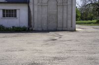 an empty parking lot in front of a building with a big stone doorway that has a door that is painted blue