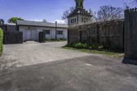 an old church steeple stands next to the entrance gate and gated in area