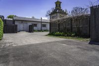 an old church steeple stands next to the entrance gate and gated in area