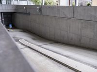 a skateboarder is in a concrete parking garage space riding down a road and looking at the ground